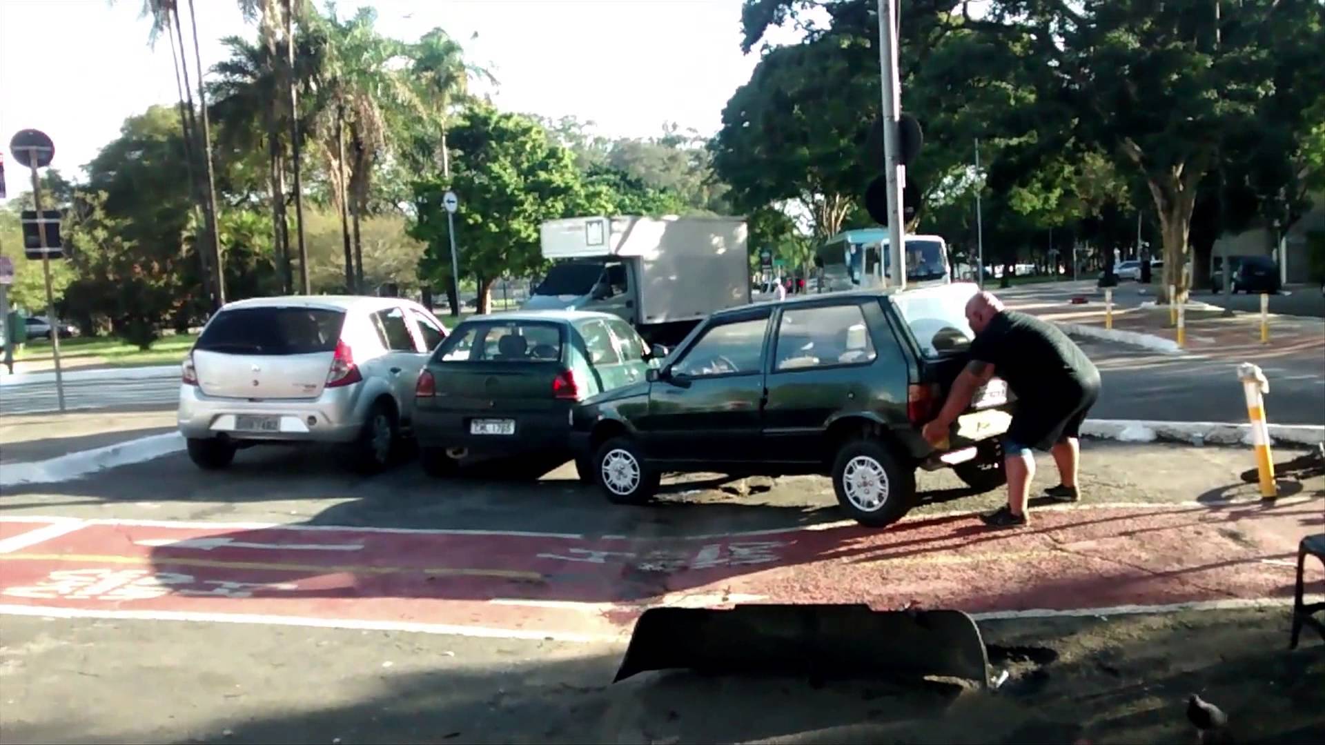Strong man lifts car off bike lane